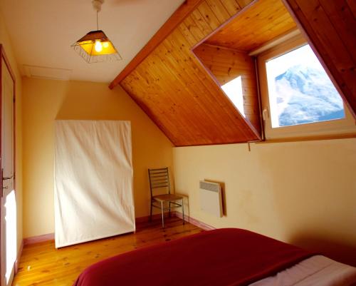 ein Schlafzimmer mit einem Fenster, einem Bett und einem Stuhl in der Unterkunft GS2 DUPLEX 4 PERS TERRASSE 5mn LUZ 15 mn ARDIDEN in Sassis