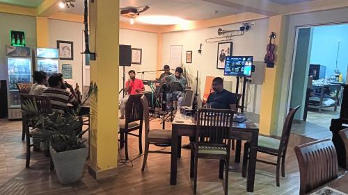 un grupo de personas sentadas en una mesa en un restaurante en This Is It Airport Hotel and Restaurant, en Negombo