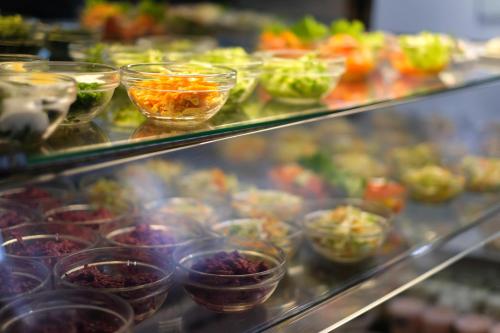 a display case with a bunch of bowls of food at Hostel Nele in Jõhvi