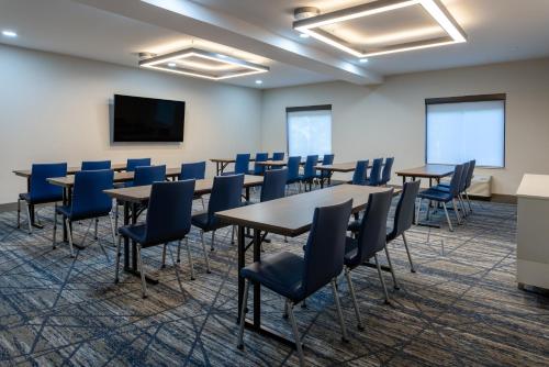 a conference room with tables and chairs and a screen at Holiday Inn Express Hotel & Suites Vineland Millville by IHG in Vineland
