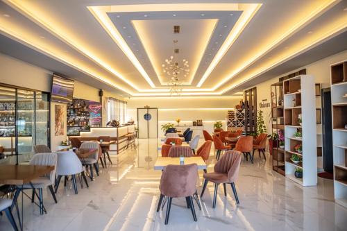 a lobby of a restaurant with tables and chairs at Hotel Univers in Kolgecaj