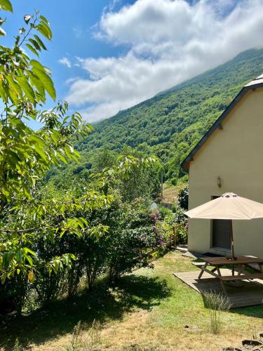 - une table de pique-nique avec un parasol à côté d'un bâtiment dans l'établissement GS4 DUPLEX 4 PERS TERRASSE 5mn LUZ 15mn ARDIDEN, à Sassis