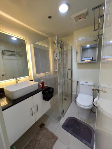 a bathroom with a toilet and a sink and a shower at Brenthill Baguio condo unit near SM baguio in Baguio