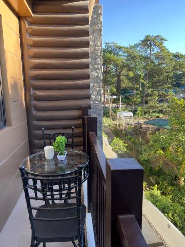 a balcony with a glass table and chairs on it at Brenthill Baguio condo unit near SM baguio in Baguio