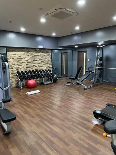 a gym with exercise equipment and a brick wall at Brenthill Baguio condo unit near SM baguio in Baguio