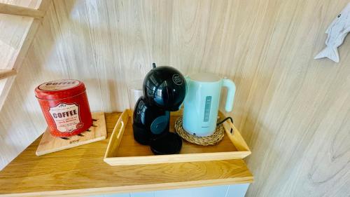 a wooden shelf with a coffee maker and a can on it at Tiny house proche de Morgat in Crozon
