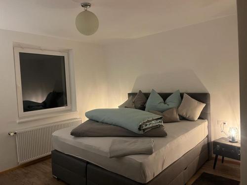 una cama con almohadas en una habitación en Ferienwohnung Defreggerhof en Winklern