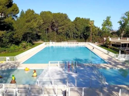 une grande piscine avec de l'eau bleue dans l'établissement T2 climatisé avec piscine, tennis et parking à 200 m des plages - FR-1-316-96, à Six-Fours-les-Plages