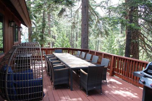 a wooden deck with a wooden table and chairs at Luna Cabin - 5BR Hot Tub A/C Game Room EV Charger in Tahoe Vista