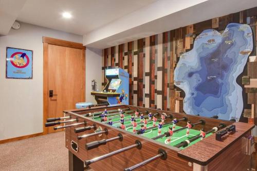 a room with a foosball table in front of a wall at Luna Cabin - 5BR Hot Tub A/C Game Room EV Charger in Tahoe Vista