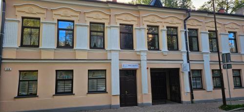 um edifício com muitas janelas e uma porta em Neiroprakse Mini Hotel em Daugavpils