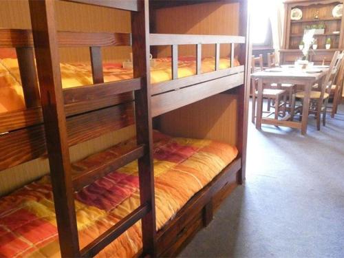 two bunk beds in a room with a table at Studio Saint-Lary-Soulan, 1 pièce, 4 personnes - FR-1-457-254 in Saint-Lary-Soulan