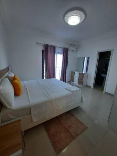 een slaapkamer met een groot wit bed en een raam bij Appartement Paisible in Dakar