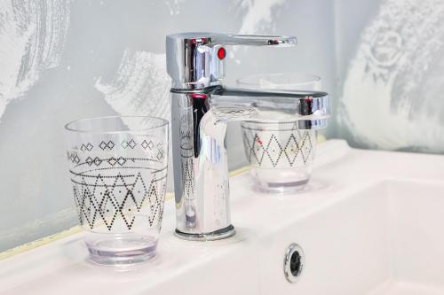 a sink with a mixer and a glass on it at Tinyhouses - Domain "La vallée des Prés" in Bande