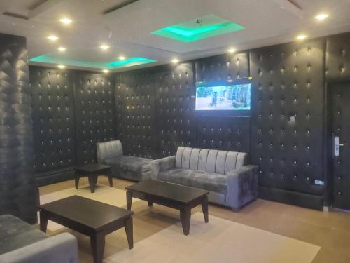 a waiting room with couches and a tv and tables at M View Hotel in Benin City