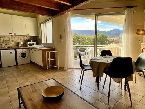 une cuisine et une salle à manger avec une table et des chaises dans l'établissement Appartement 4 pers, calme, proche mer, parking privé, clim, loggia, incluant ménage fin de séjour - FR-1-225-763, à Argelès-sur-Mer