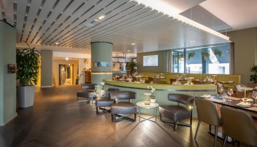 um restaurante com cadeiras e mesas e um bar em The Morrison Dublin, Curio Collection by Hilton em Dublin