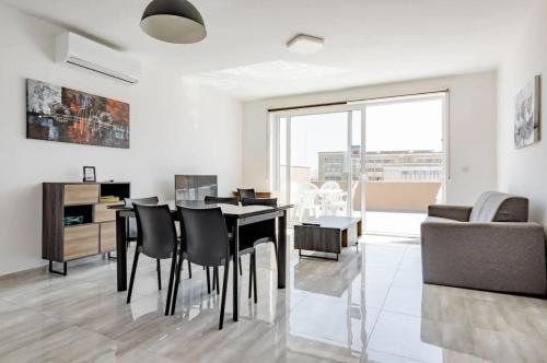 a living room with a table and chairs and a couch at F12 Modern and Bright Apartment in Malta in Msida