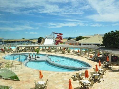 a large swimming pool with chairs and umbrellas at Resort Lacqua Park DiRoma in Caldas Novas