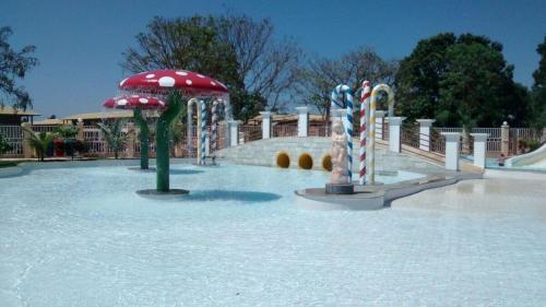 un parque acuático con parque infantil con sombrillas rojas y blancas en Resort Lacqua Park DiRoma, en Caldas Novas