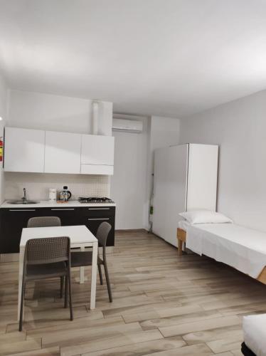 a kitchen and a bedroom with a bed and a table at Dalmati House San Lorenzo in Rome