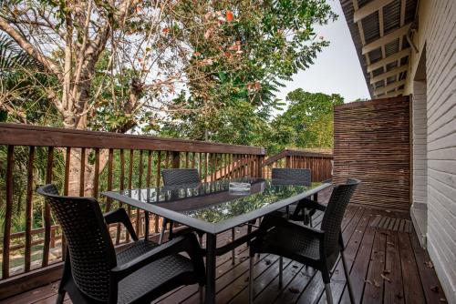 un patio con mesa y sillas en una terraza en Bushbaby Valley Lodge, en Hazyview