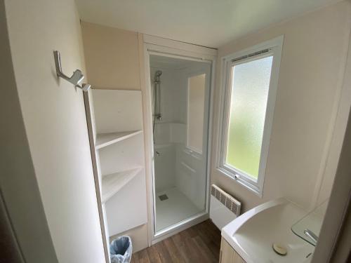 a bathroom with a walk in shower next to a sink at MOBIL HOME Clim BOOFZHEIM 6 PERSONNES 3 CHAMBRES LE RIED 3 ETOILES PROCHE EUROPA PARK in Boofzheim