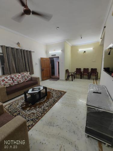 S A Villa في حيدر أباد: غرفة معيشة مع أريكة وطاولة