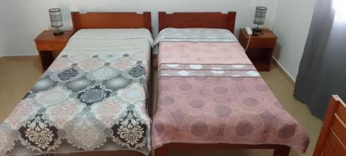 two beds sitting next to each other in a room at Residencial Aeroporto in São Tomé