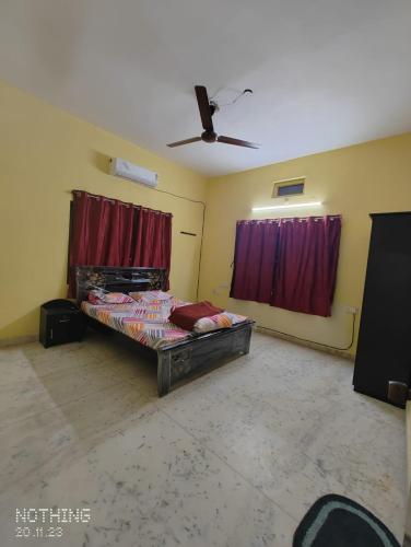 a bedroom with a bed in a room with red curtains at S A Villa in Hyderabad