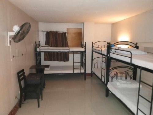 um quarto com 3 beliches e uma cadeira em D' Loft Inn CDO em Cagayan de Oro