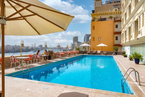 una piscina en la azotea de un hotel con sombrilla en Carlton Tower Hotel en Dubái