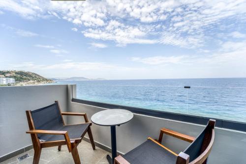 a balcony with two chairs and a table and the ocean at Island Sea Side Hotel - Adults Only in Rhodes Town