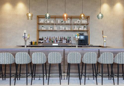 a bar with chairs in front of a counter at Hilton Garden Inn Stoke On Trent in Stoke on Trent
