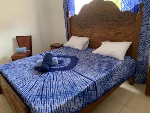 Schlafzimmer mit einem Bett mit blauer Decke in der Unterkunft Tilo Lodge in Banjul