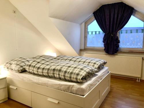 Schlafzimmer mit einem Bett und einem Fenster in der Unterkunft Lotus Apartment in Fichtenberg