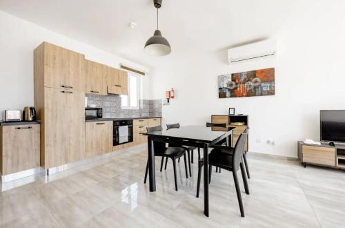 a kitchen and dining room with a black table and chairs at F12-1 Room 2 single beds shared bathroom in shared Flat in Msida