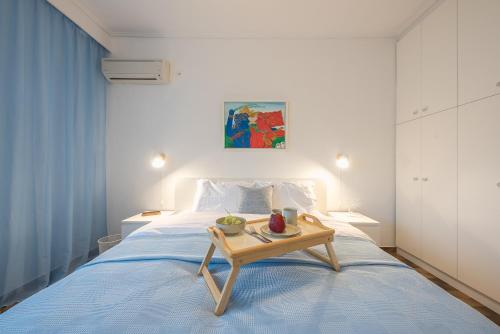 a bedroom with a bed with a tray of fruit on it at escape to sounio cape in Panayía
