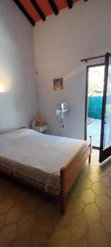 une chambre avec un grand lit et une fenêtre dans l'établissement LE LAGON Maison avec immense terrasse - piscine partagée et plage à 300 m, à Saint-Cyprien