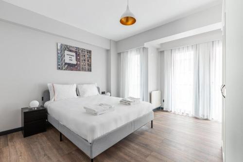 een witte slaapkamer met een groot wit bed en ramen bij Charming Bright New 2bd1bath Home Wparking!#339 in Istanbul
