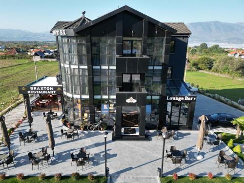 a building with tables and chairs in front of it at HOTEL BRAXTON in Bulqizë