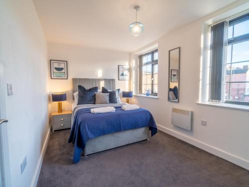 a bedroom with a blue bed and two windows at Pass the Keys Beautiful 1 bedroom apartment in Nottingham