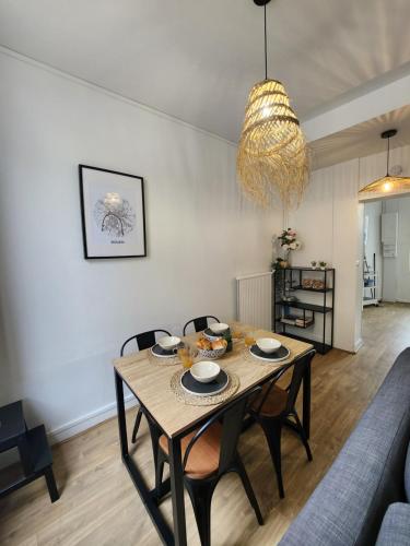 a dining room with a table and chairs in a living room at Détente en centre-ville in Rouen