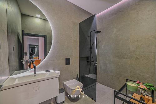 uma casa de banho com um lavatório, um WC e um espelho. em ARHEYA 1 apart Архея 1 апартамент за гости em Karlovo