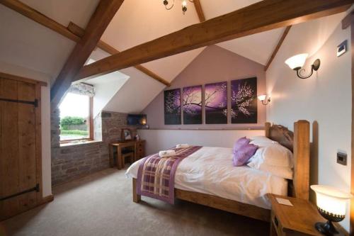 una camera da letto con un grande letto in mansarda di Oak Barn a Brecon