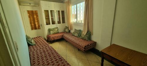 een kamer met 3 bedden en een raam bij appartement adam in Oujda