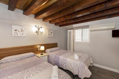 ein Schlafzimmer mit zwei Betten und einem Fenster in der Unterkunft Pensión Riosol in Sevilla