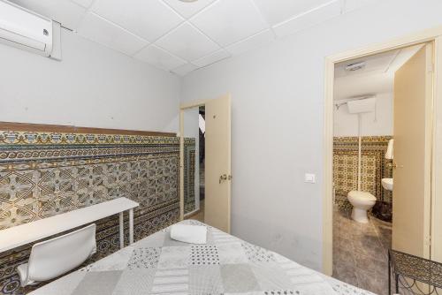 a bathroom with a bed and a toilet at Pensión Riosol in Seville