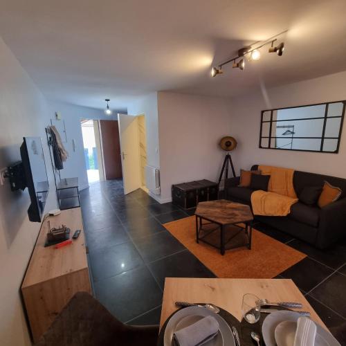 un salon avec un canapé et une table dans l'établissement L'oasis d'Anatole, à Oyonnax