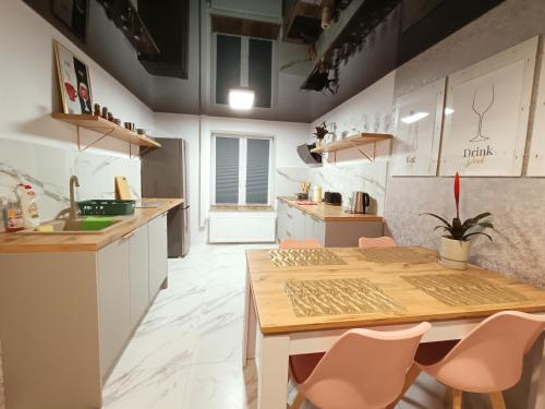 a kitchen with a wooden table and chairs at Apartamenty Centrum- Wojska Polskiego in Słupsk